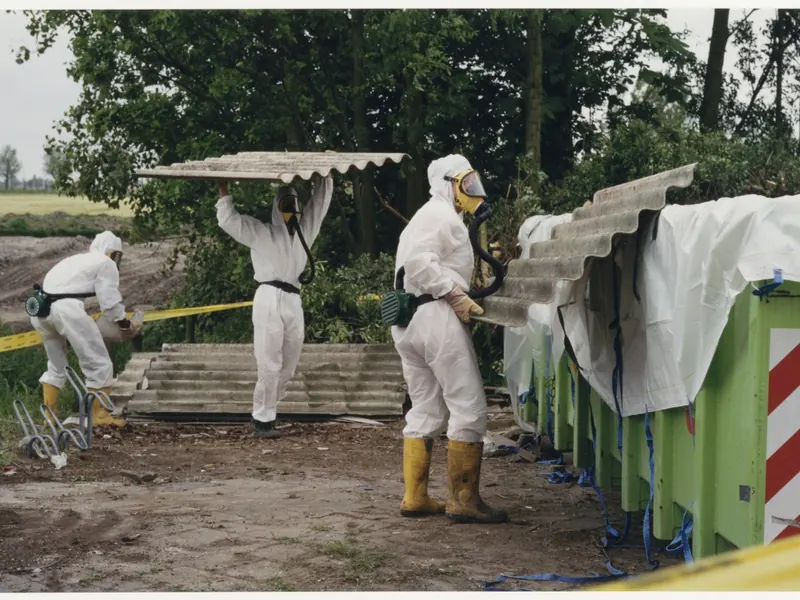 Opérateurs en combinaison et masque déposant des plaques de fibrociment