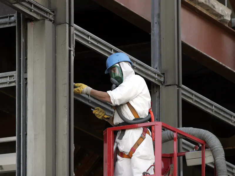 Opérateur de désamiantage avec masque à ventilation assistée